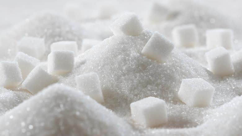 Sugar cubes sitting on a pile of granulated sugar