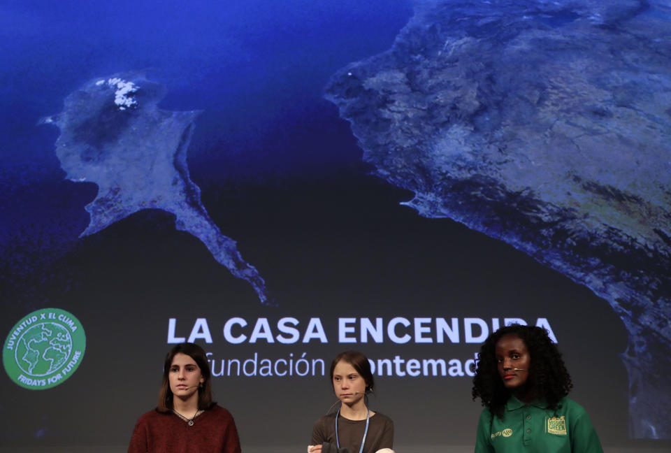 Climate activist Greta Thunberg, centre, attends a press conference in Madrid, Friday Dec. 6, 2019. Thunberg arrived in Madrid Friday to join thousands of other young people in a march to demand world leaders take real action against climate change. (AP Photo/Bernat Armangue)