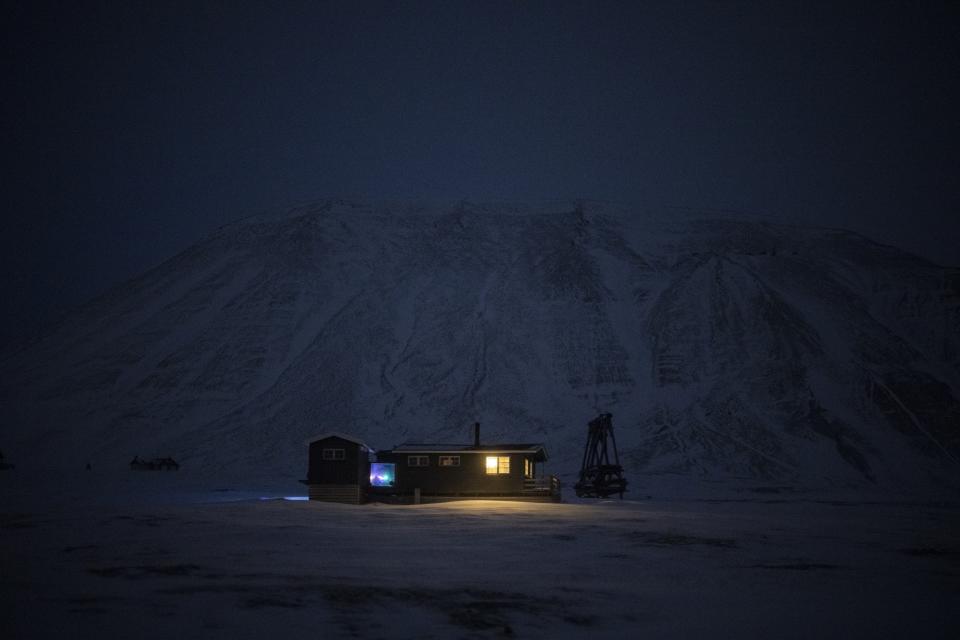 La cabaña Svalbard Kirke ilumina la noche polar en Bolterdalen, Noruega, el lunes 9 de enero de 2023. Tan cerca del Polo Norte, el sol está al menos seis grados bajo el horizonte de mediados de noviembre hasta finales de enero. (AP Foto/Daniel Cole)