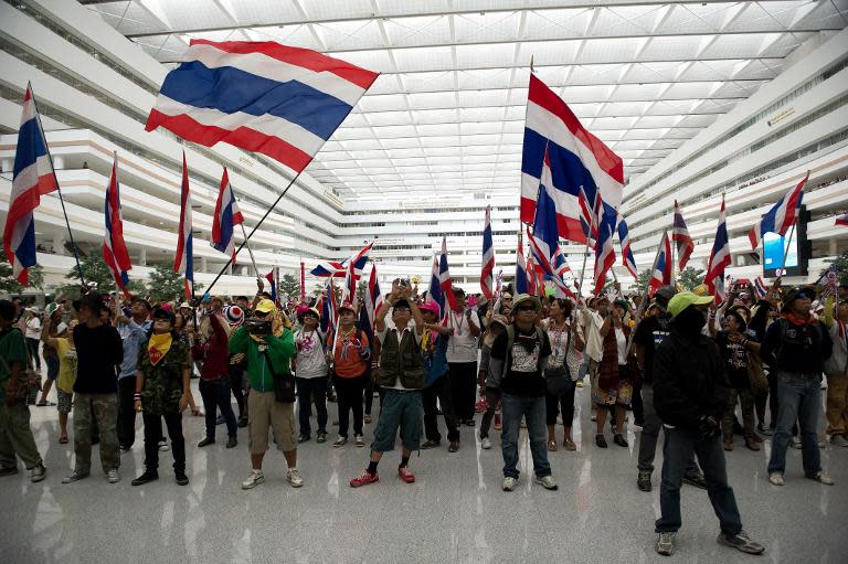 Thai anti-government protesters shout slogans and wave flags inside a government complex during a rally in Bangkok, on April 1, 2014