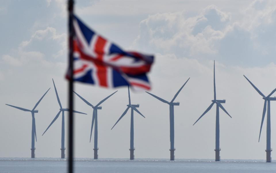 Gunfleet Sands offshore wind farm turbines can be seen as a Union Jack flag flies on September 29, 2022 in Clacton-On-Sea - John Keeble