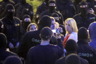 Two women talk with police officers surrounded protesters during a Belarusian opposition supporters rally at Independence Square in Minsk, Belarus, Wednesday, Aug. 26, 2020. Protests demanding the resignation of Belarus' authoritarian President Alexander Lukashenko have entered their 18th straight day on Wednesday. (AP Photo/Sergei Grits)