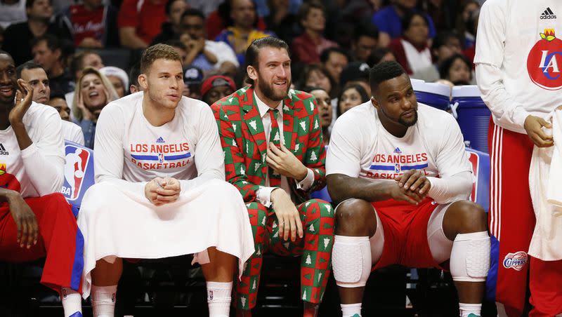 Los Angeles Clippers’ Spencer Hawes, center, wears a Christmas themed suit as he sits on the bench between Blake Griffin, left, and Glen Davis, right, during a game against the Golden State Warriors on Dec. 25, 2014, in Los Angeles.