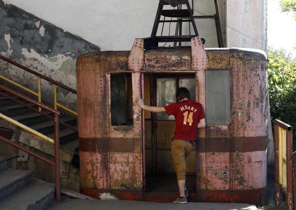 A boy stands at the door of a 60-year-old cable car in the town of Chiatura