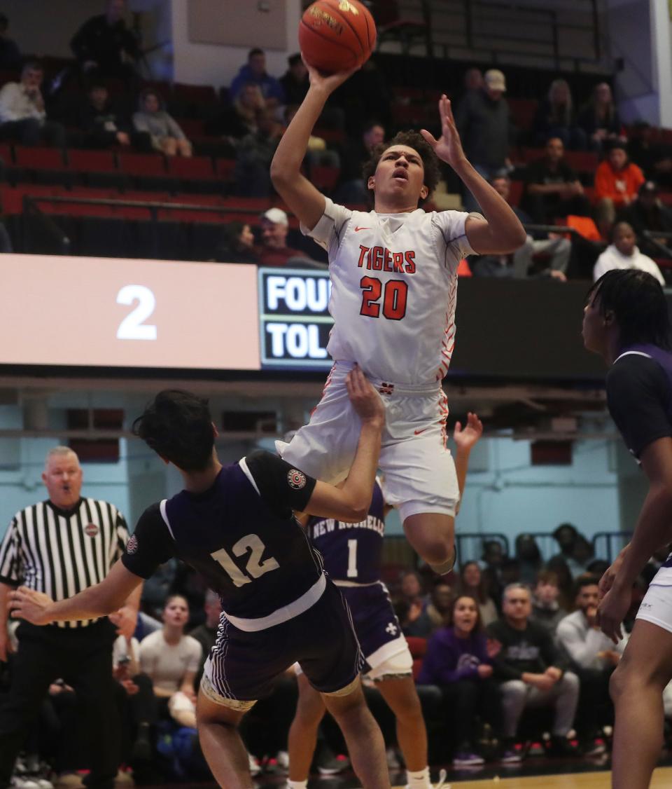 Mamaroneck's Cosmo Hardinson (20) goes up for a shot in front of New Rochelle's Kasim Mirza (12) during the Section 1 Class AAA semifinal at the Westchester County Center in White Plains Feb. 28, 2024. New Rochelle won the game in overtime 52-50.