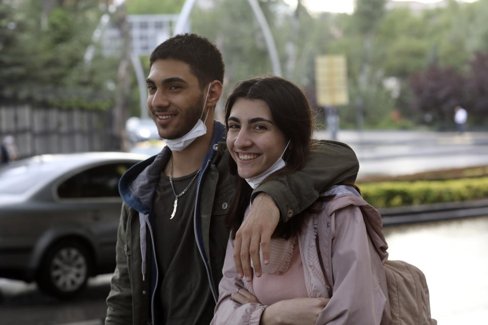 A maskless couple walk in a popular street, in Ankara, Turkey, Wednesday, June 17, 2020. Turkey has made the wearing of face masks mandatory in five more provinces, following an uptick in COVID-19 cases. Health Minister Fahrettin Koca tweeted Tuesday that the wearing of masks is now compulsory in 42 of Turkey's 81 provinces.(AP Photo/Burhan Ozbilici)