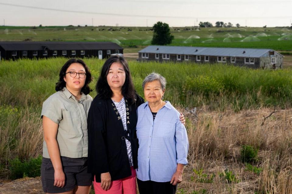 Minidoka survivor Mary Tanaka Abo, 83, at right, poses for a portrait with daughter Julie Abo, center, and granddaughter Maya Abo Dominguez, left, in front of a historic mess hall and barracks. Tanaka Abo says she didn’t want Julie or Maya to feel the same sense of shame surrounding incarceration as she did. Instead, she chose to speak openly about her experience with her daughter and granddaughter, and has attended multiple pilgrimages with her family. Lindsey Wasson/AP