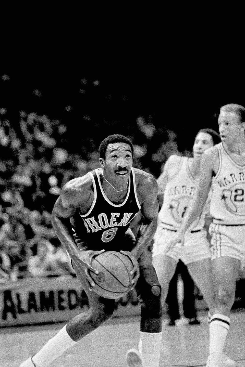 FILE - Phoenix Suns' Walter Davis, left, controls the ball against the Golden State Warriors in the first half of their NBA game in Oakland, Calif., Oct. 18, 1978. Davis, a five-time NBA All-Star who had his number retired by the Phoenix Suns, has died. He was 69. Davis was star in college for North Carolina where he played for the late Dean Smith. The school's release said Walter Davis died Thursday morning, Nov. 2, 2023, of natural causes while visiting family in Charlotte, North Carolina.(AP Photo/File)