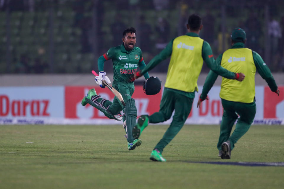 Two members of the team rush to join as Bangladesh's Mehidy Hasan Miraz, left, celebrates after winning the first one day international cricket match against India in Dhaka, Bangladesh, Sunday, Dec.4, 2022. (AP Photo Surjeet Yadav)