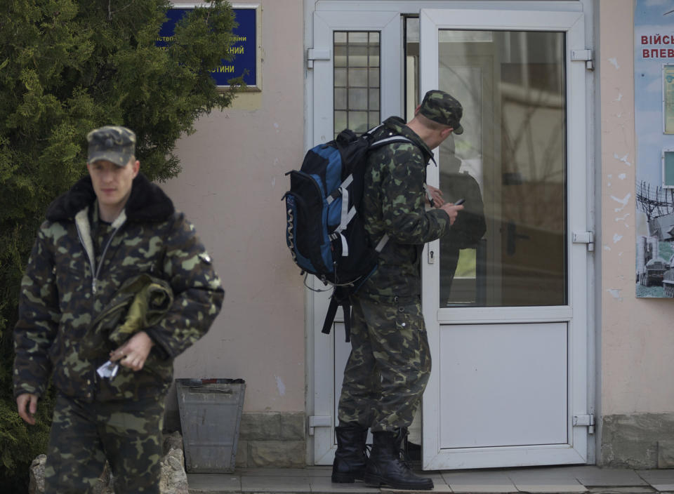 Ukrainian air force officers walk with their bags at the Belbek airbase, outside Sevastopol, Crimea, on Thursday, March 20, 2014. With thousands of Ukrainian soldiers and sailors trapped on military bases, surrounded by heavily armed Russian forces and pro-Russia militia, the Kiev government said it was drawing up plans to evacuate its outnumbered troops from Crimea back to the mainland and would seek U.N. support to turn the peninsula into a demilitarized zone. (AP Photo/Ivan Sekretarev)