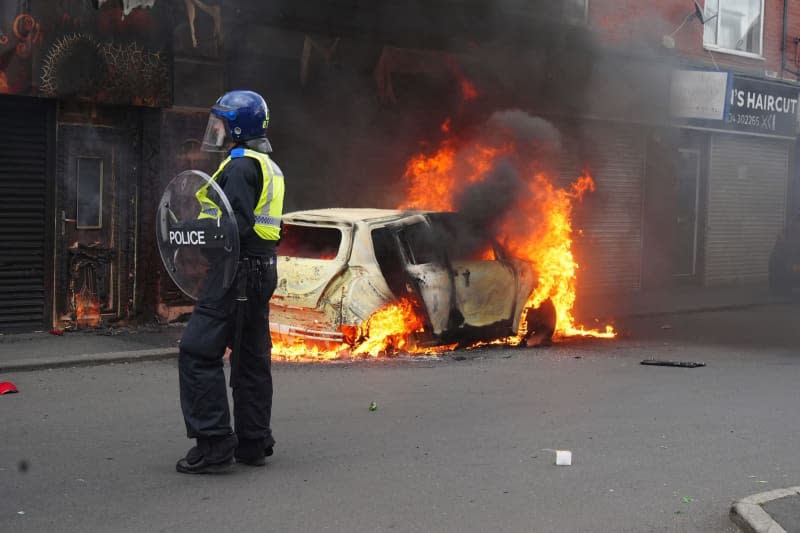 A car burns on Parliament Road in Middlesbrough during an anti-immigration demonstration. After the knife attack on children in Southport on 29 July 2024, numerous nationalist and anti-Islamic protests inflame the mood in the UK. Owen Humphreys/PA Wire/dpa