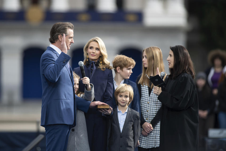 CORRECTS SPELLING OF SURNAME TO NEWSOM - Jennifer Siebel Newsom and the first family watch Chief Justice Patricia Guerrero swears in Governor Gavin Newsom during governor's inauguration in the Plaza de California in Sacramento, Calif., Friday, Jan. 6, 2023. (AP Photo/José Luis Villegas)