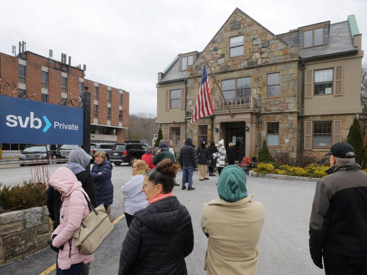 Customers wait in line outside a branch of the Silicon Valley Bank in Wellesley, Massachusetts, U.S., March 13, 2023.  (Brian Snyder/Reuters - image credit)