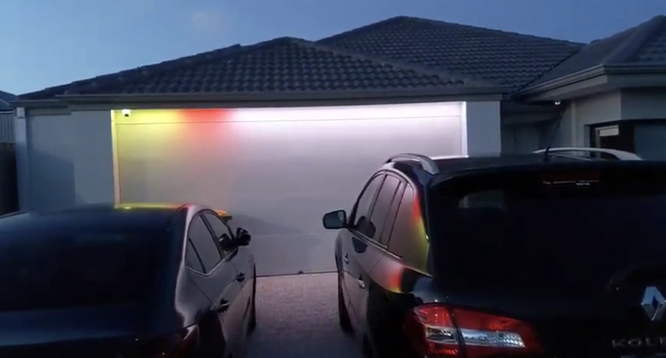 A Perth man's LED light display on his garage door, flashing yellow, reminding him of recycling bin night. 