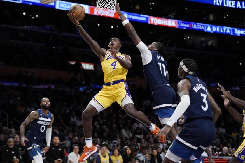 Los Angeles Lakers' Lonnie Walker IV shoots against Minnesota Timberwolves' Naz Reid during first half of an NBA preseason basketball game Wednesday, Oct. 12, 2022, in Los Angeles. (AP Photo/Jae C. Hong)