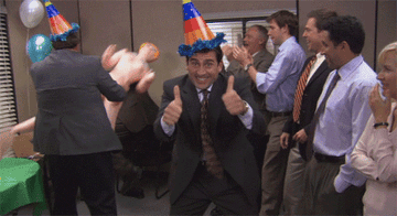 Michael gives two thumbs up while Kevin beats Dwight with a blow up doll at an office party in The Office