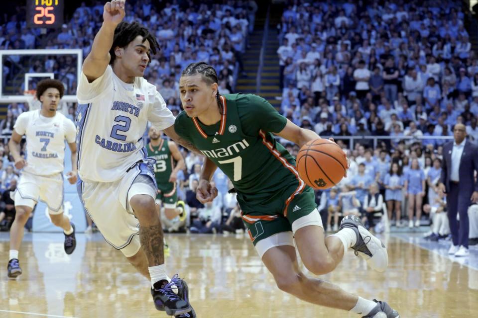 Miami guard Kyshawn George (7) drives against North Carolina guard Elliot Cadeau (2)