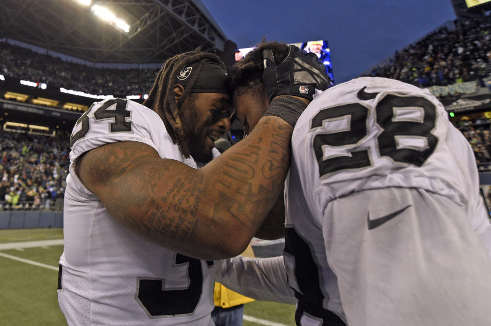 Las Vegas Raiders running back Brandon Bolden (34) and running back Josh Jacobs (28) celebrate after an overtime win over the Seattle Seahawks during an NFL football game Sunday, Nov. 27, 2022, in Seattle. (AP Photo/Caean Couto)