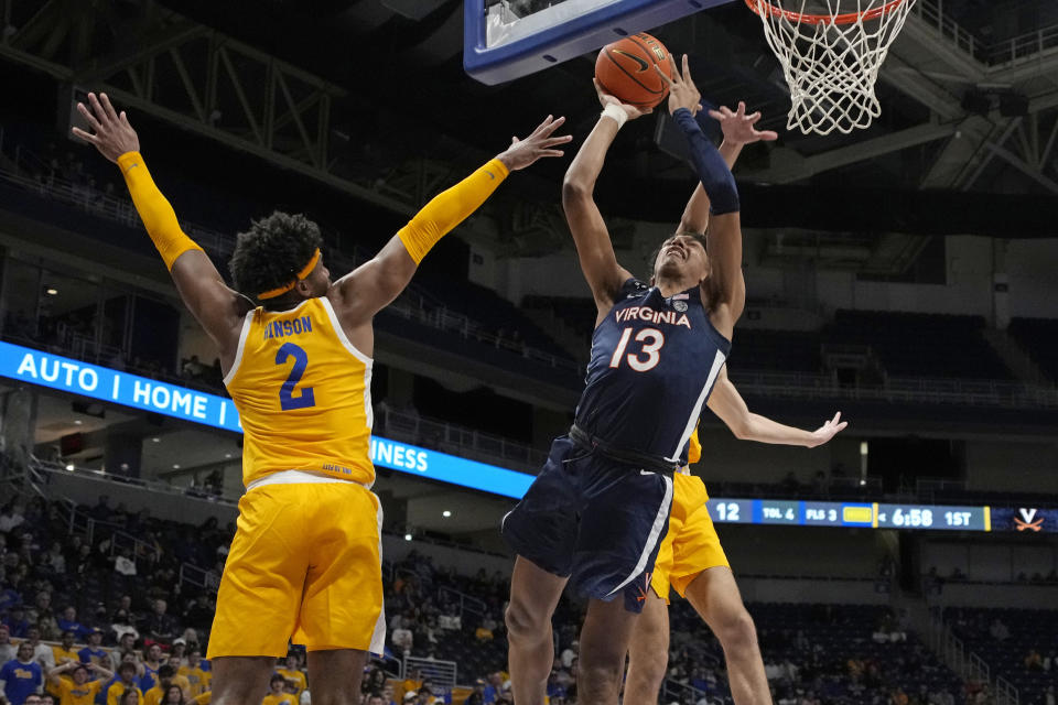 Virginia guard Ryan Dunn (13) gets off a shot with Pittsburgh forward Blake Hinson (2) and Pittsburgh center Federiko Federiko, rear, defending during the first half of an NCAA college basketball game in Pittsburgh, Tuesday, Jan. 3, 2023. (AP Photo/Gene J. Puskar)