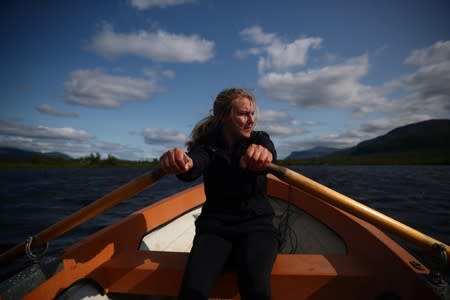 Kathryn Bennett, a postgraduate student in earth sciences at the University of New Hampshire, rows across a lake at a research post at Stordalen Mire near Abisko
