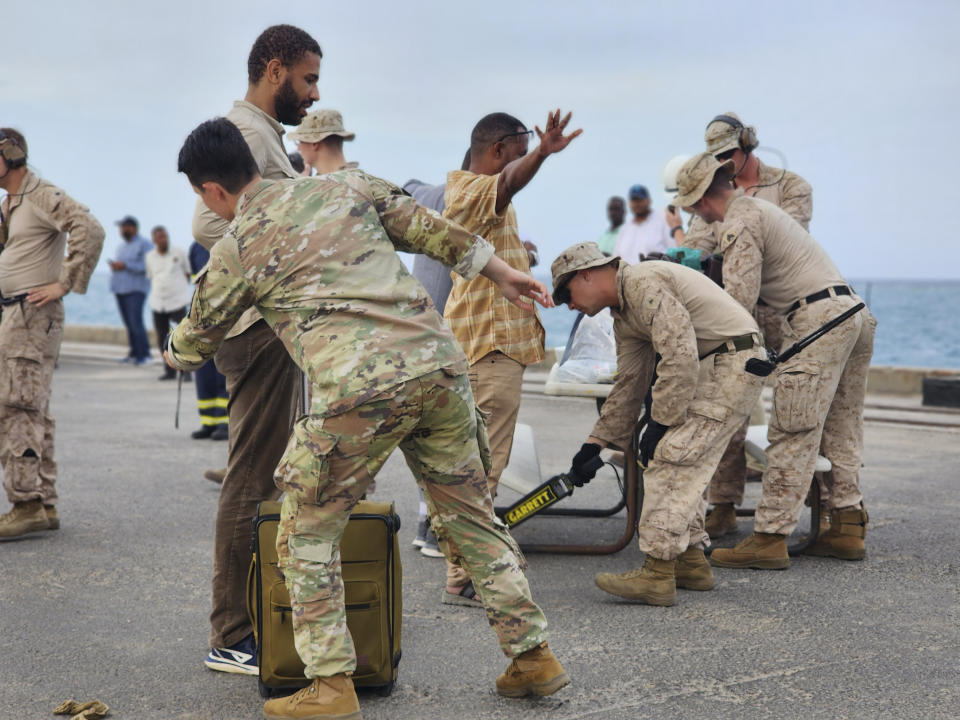 American nationals are searched by the U.S. soldiers before boarding a ship in Port Sudan, Sunday, April 30, 2023. Sudan's army and its rival paramilitary say they will extend a humanitarian cease-fire another 72 hours as of midnight. The decision follows international pressure to allow the safe passage of civilians and aid but also comes after days of continued fighting despite the earlier truce. (AP Photo/Smowal Abdalla)