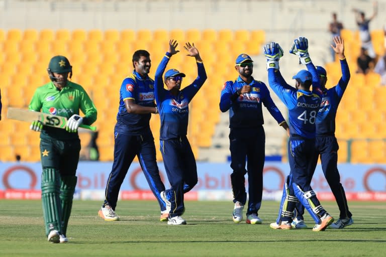 Pakistan's Shoaib Malik (L) leaves the field after being dismissed by Sri Lanka's Nickwella Dickwella during their second one day international (ODI) match at Sheikh Zayed Stadium in Abu Dhabi on October 16, 2017