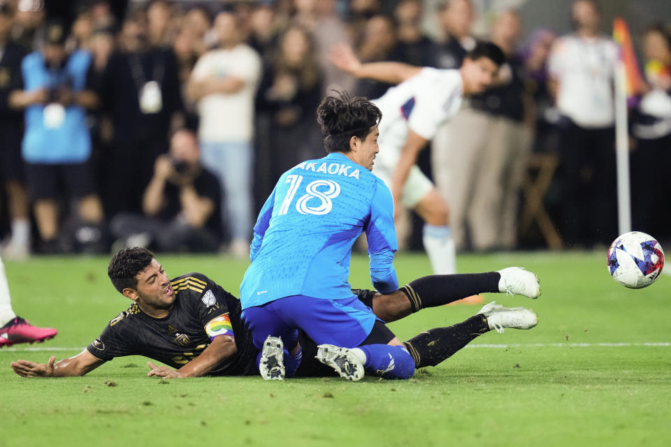 Los Angeles FC forward Carlos Vela (10) collides with Vancouver Whitecaps goalkeeper Yohei Takaoka (18) as he shoots during the second half of an MLS soccer match in Los Angeles, Saturday, June 24, 2023. (AP Photo/Ashley Landis)