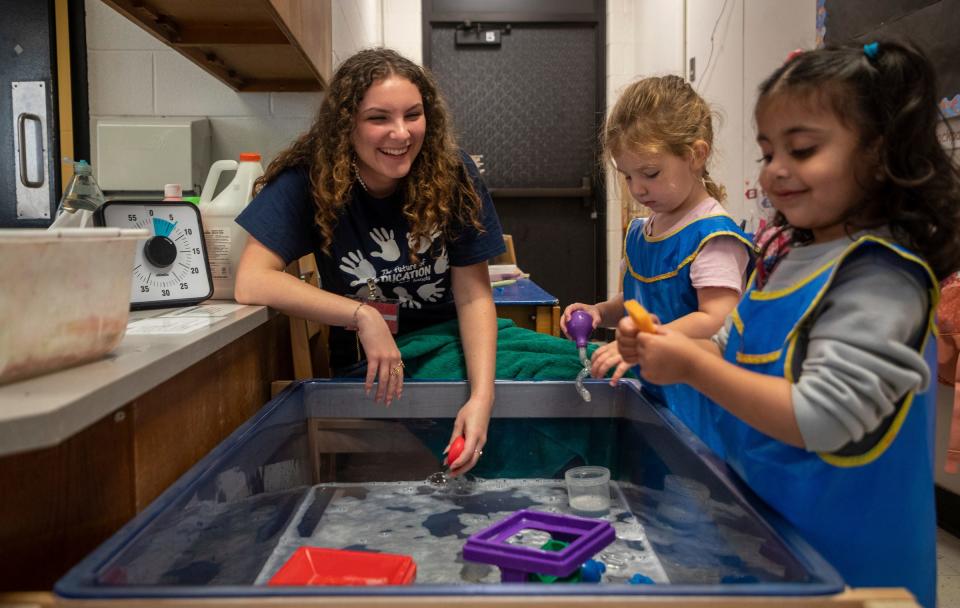 Pebble Payeur, a student at Canton High School, smiles as she plays with two preschool students during a Kiddie Campus class in Canton on Oct. 26, 2023. The Kiddie Campus class is one of the specialized classes offered at the Plymouth-Canton Educational Park that is geared toward students who might find a career related to early childhood education or teaching..