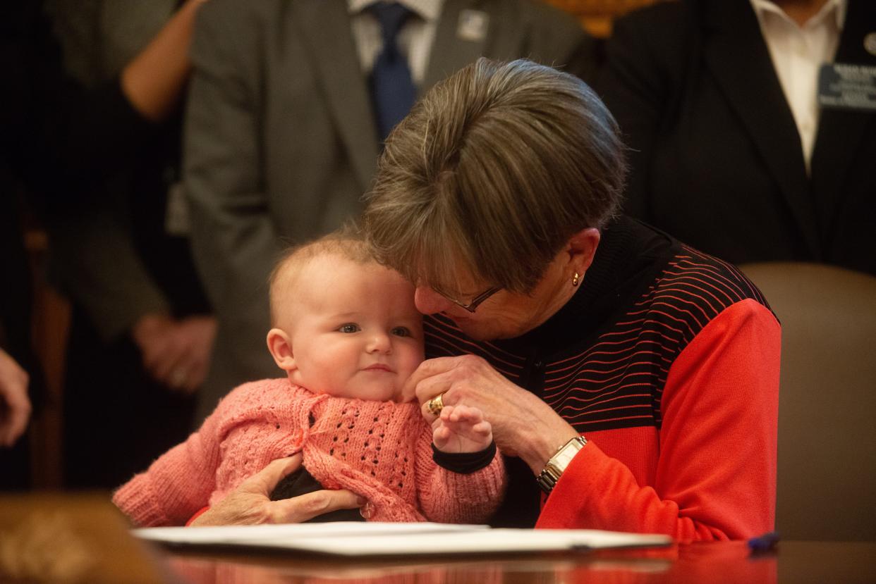 Gov. Laura Kelly holds her granddaughter, 4-month-old Laura "Rory" Janeway Weiden, after signing an executive order to create a task force to make a government agency on child care Tuesday at the Statehouse.