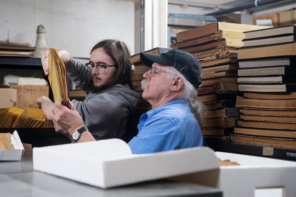 Gene Hyde, Head of Special Collections at UNC Asheville's Ramsey Library, goes through folders of photographs with help from UNCA student Michael Dennis, January 29, 2024.