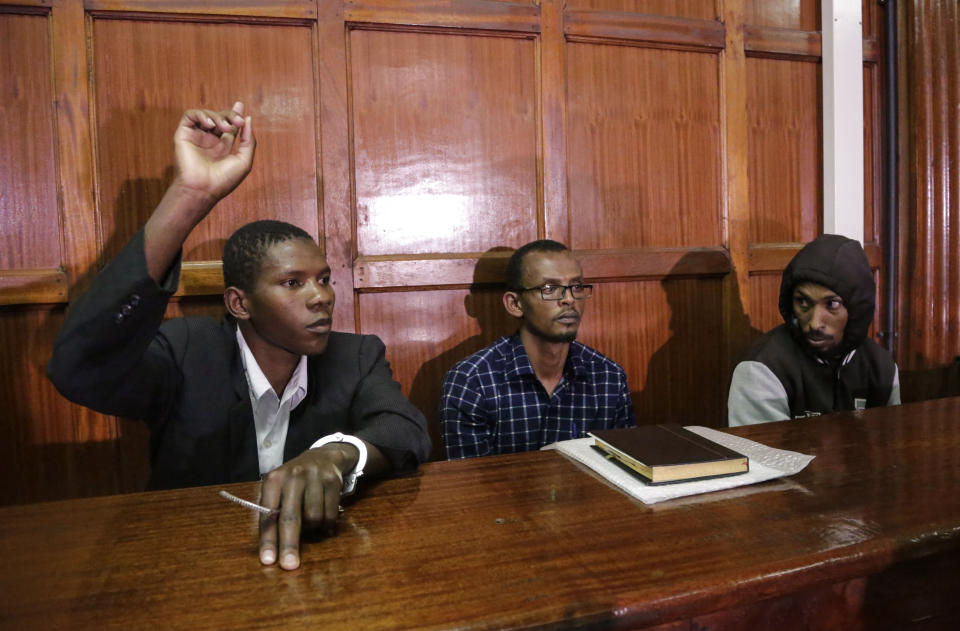 From left to right, defendants Rashid Charles Mberesero, Hassan Aden Hassan and Mohamed Abdi Abikar, sit in the dock to hear their verdict at a court in Nairobi, Kenya Wednesday, June 19, 2019. The Kenyan court found Mberesero, Hassan and Abikar guilty of conspiracy to commit a terror attack after phone records and handwriting linked them to the 2015 Garissa University assault that killed 148 people, while a fourth person, Sahal Diriye Hussein, was acquitted. (AP Photo/Khalil Senosi)