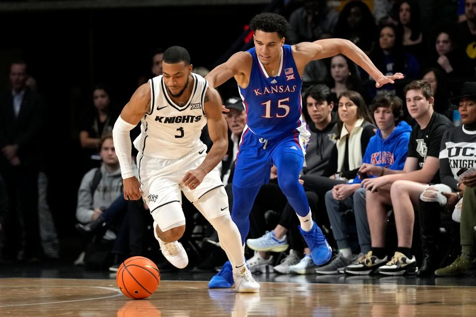Central Florida guard Darius Johnson (3) gets in front of Kansas guard Kevin McCullar Jr. (15) as they go after a loose ball during the first half of an NCAA college basketball game, Wednesday, Jan. 10, 2024, in Orlando, Fla. (AP Photo/John Raoux)