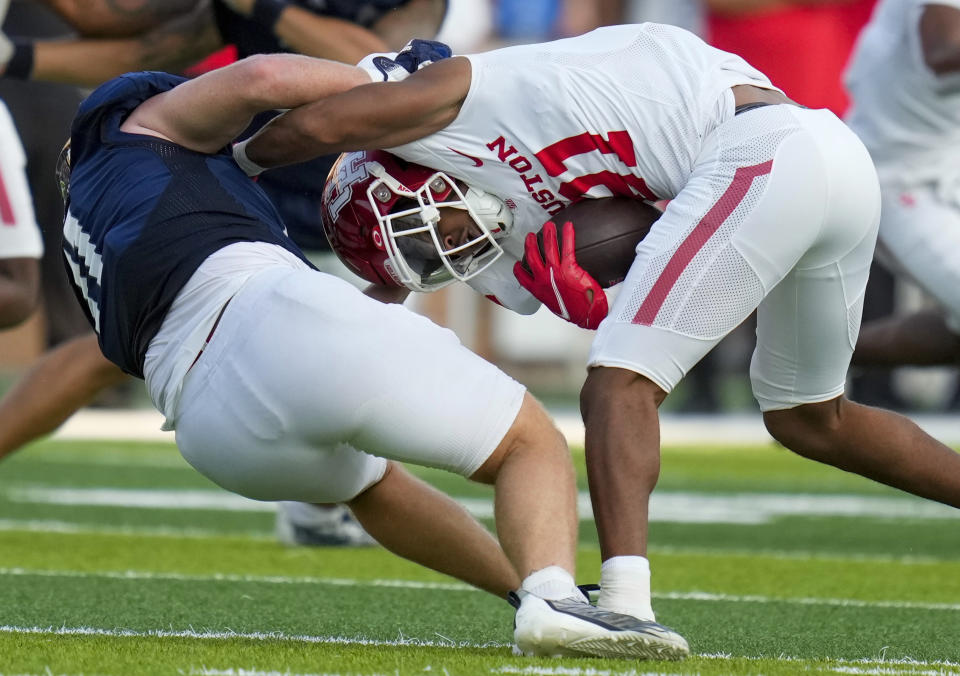 Houston running back Stacy Sneed, right, is tackled by Rice linebacker Chris Conti during the first half of an NCAA college football game, Saturday, Sept. 9, 2023, in Houston. (AP Photo/Eric Christian Smith)