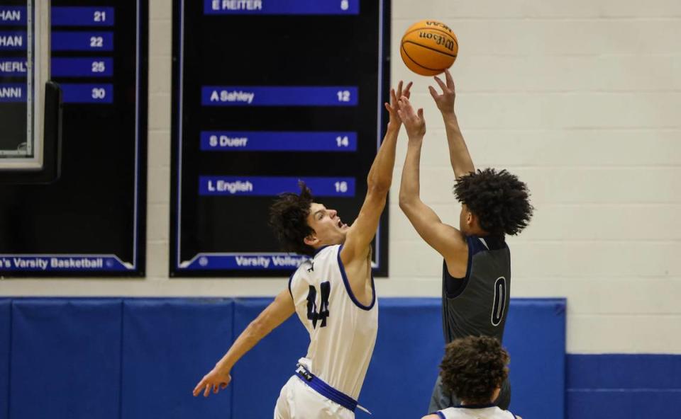 Hickory Ridge Ragin’ Bulls Parker Watkins, right, shoots past a block by Lake Norman Wildcats Trent Steinour at Lake Norman High School in Mooresville, N.C., on Tuesday, February 6, 2024.