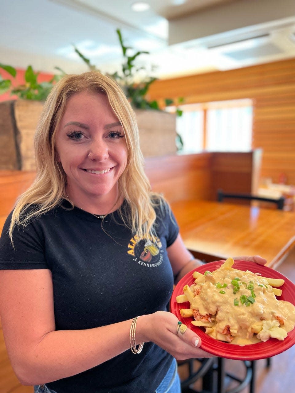 Jill Fortin, a bartender at Alisson's Restaurant in Kennebunkport, Maine, holds up a tasty lobster dish that will be on the menu for Maine Lobster Week, which launches on Monday, Sept. 19, 2022.