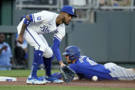 Toronto Blue Jays' George Springer (4) beats the tag by Kansas City Royals third baseman Maikel Garcia to advance to third on a single by Bo Bichette during the third inning of a baseball game Tuesday, April 23, 2024, in Kansas City, Mo. (AP Photo/Charlie Riedel)