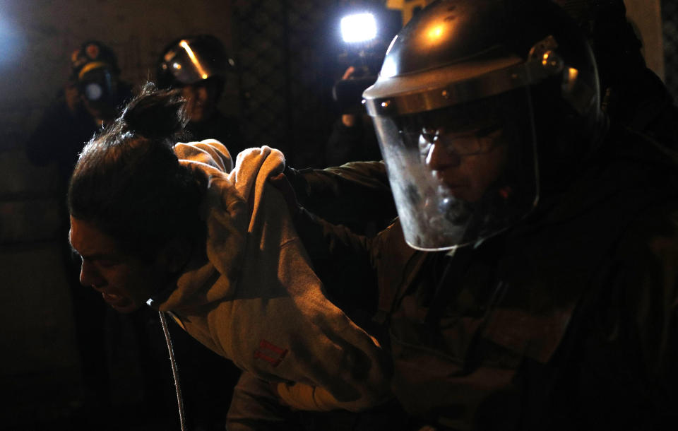 Riot police detain a protester who is against the reelection of President Evo Morales, in La Paz, Bolivia, Thursday, Oct. 31, 2019. Violence has escalated since Morales was declared the winner of the Oct. 20 vote amid delays in the vote count. The opposition alleges the outcome was rigged to give Morales enough of a majority to avoid a runoff election; the president denies any irregularities. (AP Photo/Juan Karita)