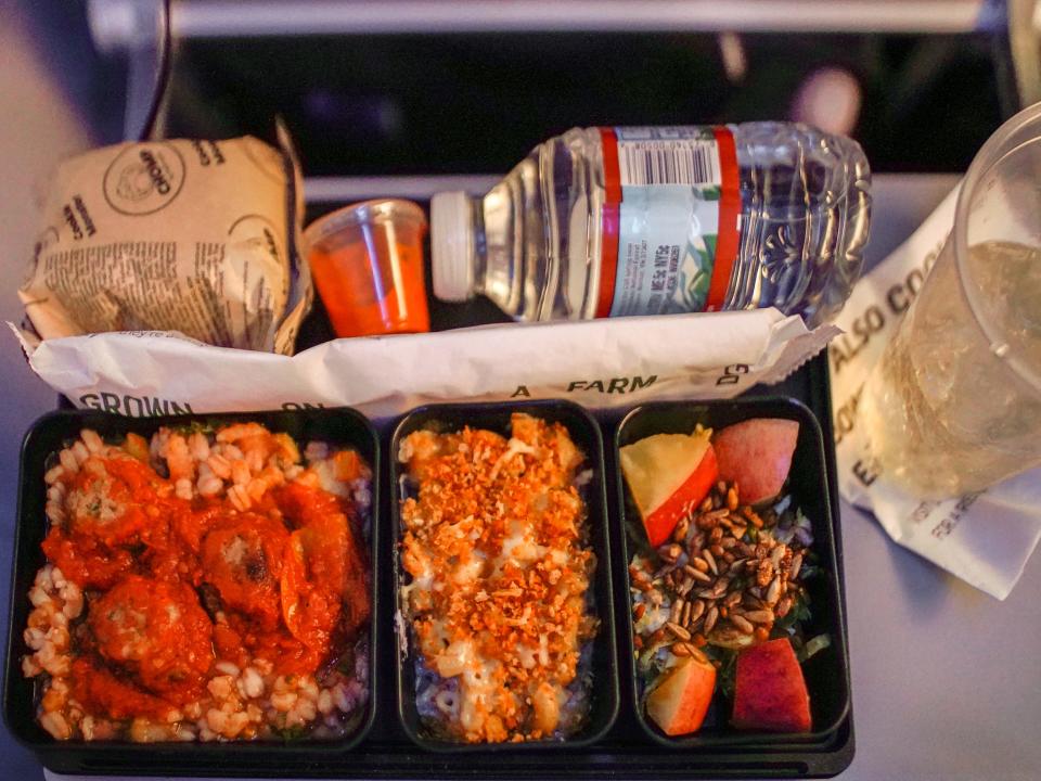 A red plane meal on a tray table on a flight