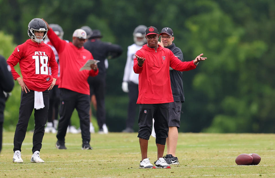 FLOWERY BRANCH, GA - 14 MEI: Quarterback Kirk Cousins ​​#18 kijkt toe terwijl Atlanta Falcons-hoofdcoach Raheem Morris praat over aanval en verdediging tijdens OTA's buiten het seizoen tijdens de Atlanta Falcons-training op 14 mei 2024 in Flowery Branch, Georgia.  (Foto door Kevin C. Cox/Getty Images)