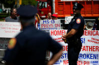 U.S. president Trump supporters hold placards against MS-13 as New York Police stand guard at the street during a forum about Central American-based Mara Salvatrucha (MS-13) gang organization at the Morrelly Homeland Security Center in Bethpage, New York, U.S., May 23, 2018. REUTERS/Eduardo Munoz