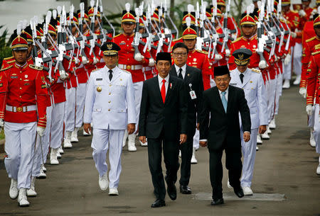 Presidential guards walk with (L-R) Jakarta Governor Anies Baswedan, Indonesia President Joko Widodo and Vice President Jusuf Kalla for a swearing-in ceremony at the Presidential Palace in Jakarta, Indonesia, October 16, 2017. REUTERS/Beawiharta