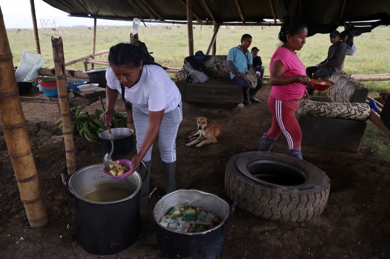 Mujeres indígenas cocinan en un campamento instalado por ellas en un cañaveral donde, según su comunidad, están liberando y recuperando la tierra de los monocultivos, en Padilla, departamento del Cauca