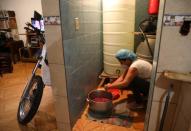 A woman cleans meat in the floor of her house in the low-income neighbourhood of Artigas amid the coronavirus disease (COVID-19) outbreak in Caracas