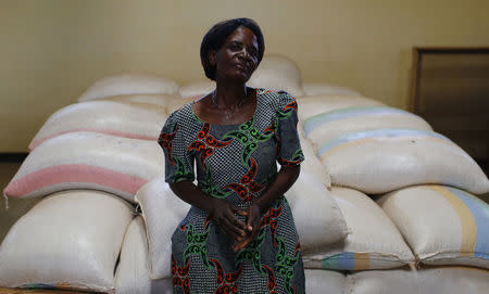 Subsistence farmer Salome Banda stands beside bags of her maize stacked in a warehouse north of Lilongwe, Malawi February 2, 2016. REUTERS/Mike Hutchings