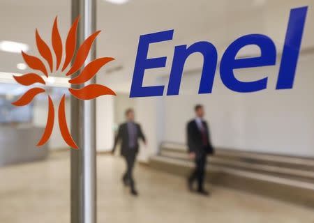 People walk past the logo of Italy's biggest utility Enel at their Rome headquarter November 11, 2014. REUTERS/Tony Gentile