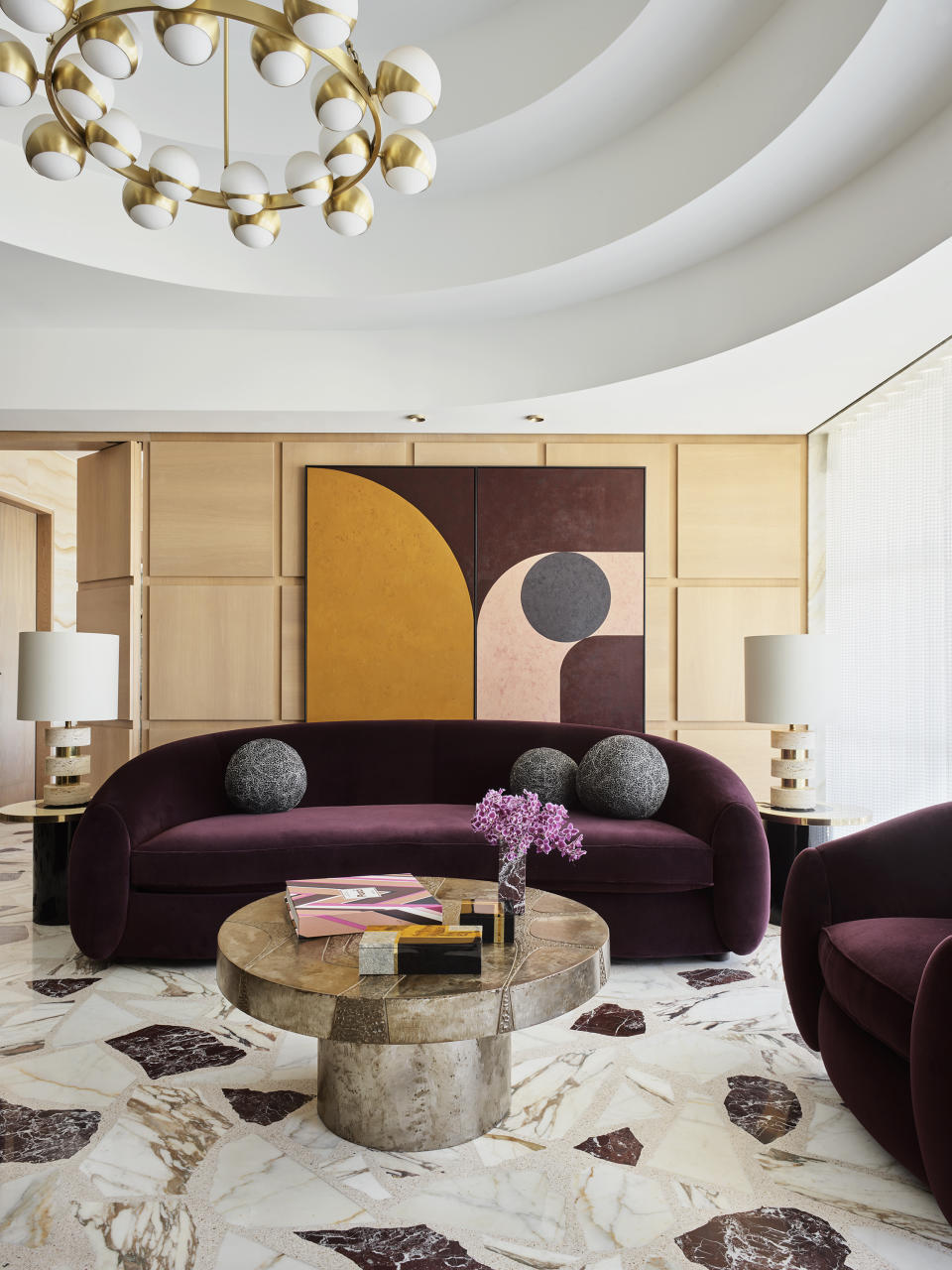 reception room with square wooden panelling, curved purple sofa and terrazzo floor