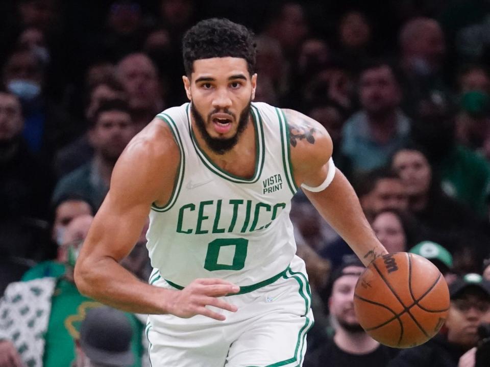 Jayson Tatum dribbles the ball up the floor.