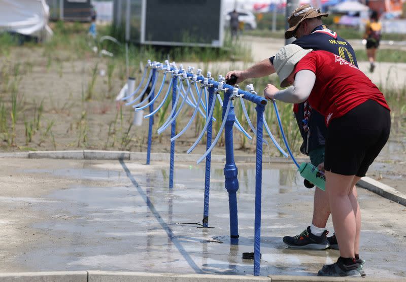 Participants for the 25th World Scout Jamboree fill water bottles at a water supply zone of a camping site in Buan