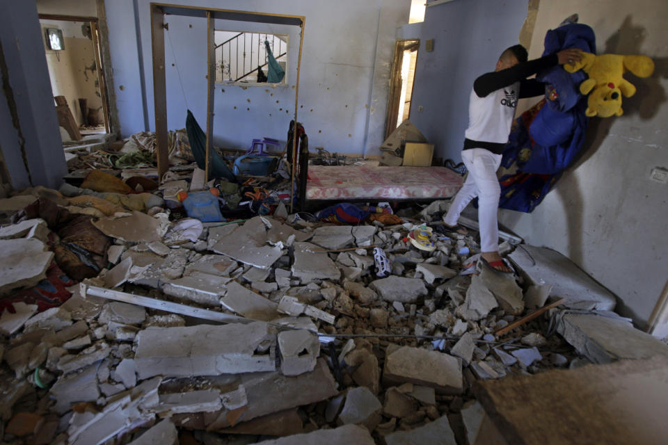 Personal belongings are removed from inside the home of Hamza Abu el-Heija, where he was killed by Israeli troops, in the West Bank refugee camp of Jenin, Saturday, March 22, 2014. Israeli troops killed at least four Palestinians in an early morning raid that was followed by a clash with angry protesters in a West Bank town on Saturday, the Israeli military and Palestinian security officials said, in the deadliest incident in months. The Israeli military said the raid aimed to arrest Hamza Abu el-Heija, a 22-year-old Hamas operative wanted for involvement in shooting and bombing attacks against Israelis. (AP Photo/Mohammed Ballas)