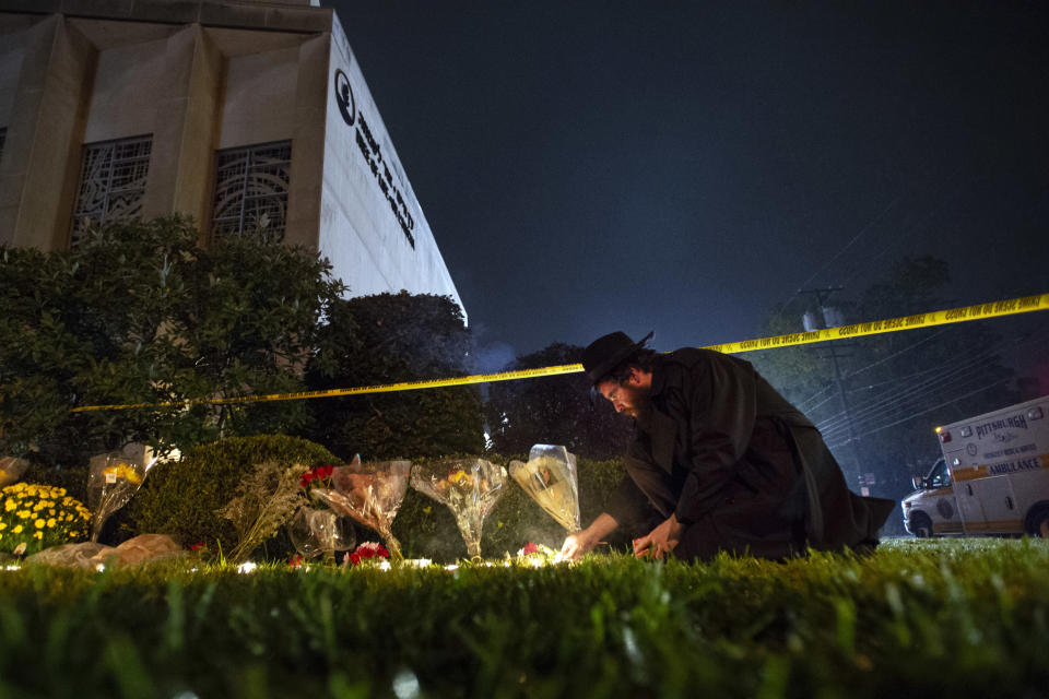 FILE - In this Oct. 27, 2018 photo, Rabbi Eli Wilansky lights a candle after a mass shooting at Tree of Life Synagogue in Pittsburgh's Squirrel Hill neighborhood. Robert Bowers, a truck driver accused of killing 11 and wounding seven during an attack on the Pittsburgh synagogue in October is expected to appear Monday, Feb. 11, 2019, morning in a federal courtroom to be arraigned on additional charges. (Steph Chamber/Pittsburgh Post-Gazette via AP, File)